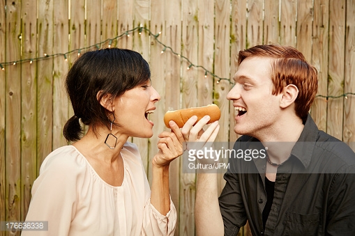 176636338-couple-sharing-hot-dog-in-garden-gettyimages.jpg