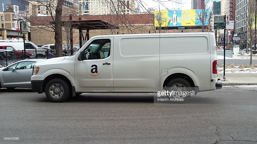view-of-a-white-delivery-van-or-truck-with-an-amazon-logo-on-its-side-picture-id599433085
