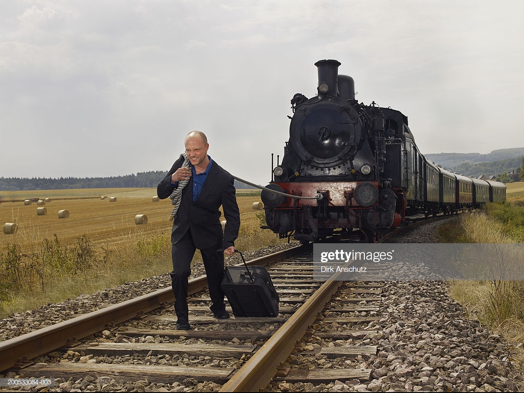man-pulling-steam-train-with-rope-holding-suitcase-picture-id200533084-003.jpg