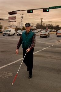 pat_higgins_crossing_street_with_cane.jpeg