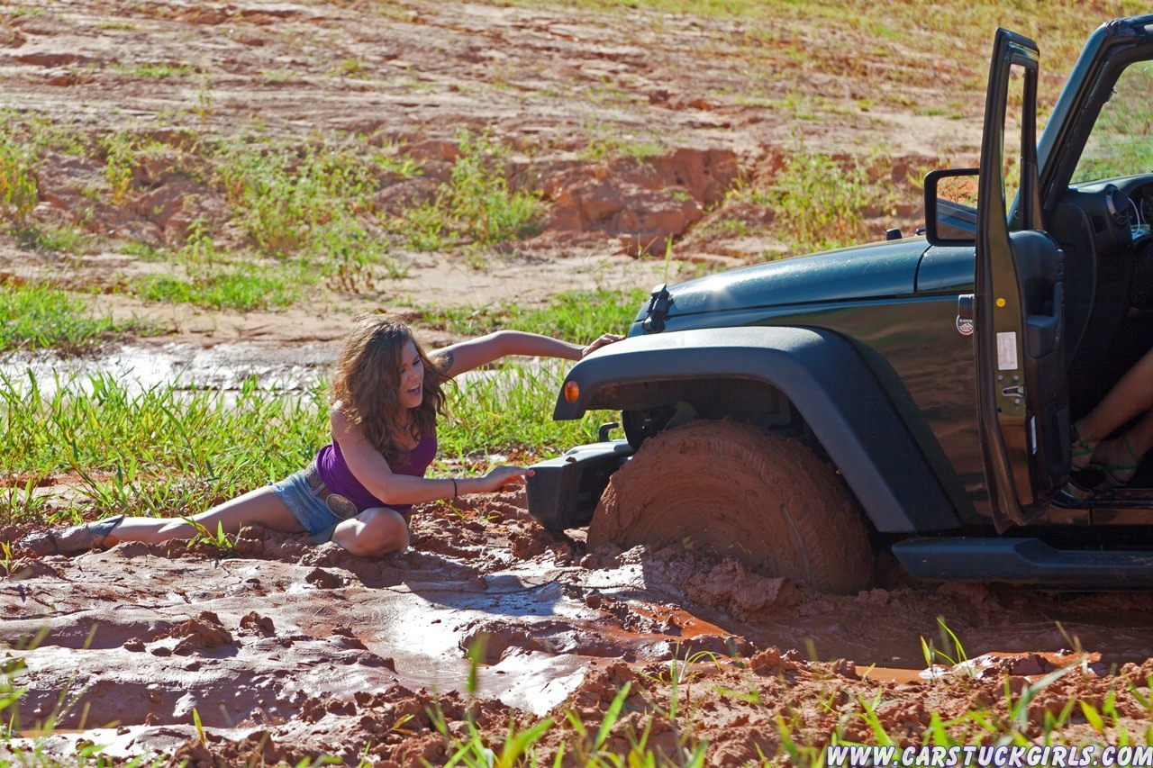 Женщина застряла в машинке. Джипы в грязи. Девушки толкают машину в грязи. Девушки и внедорожники в грязи.