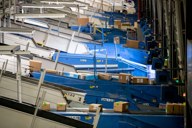 Packages ride conveyor belts into the FedEx Ground Olive Branch hub Wednesday, Dec. 4, 2019.