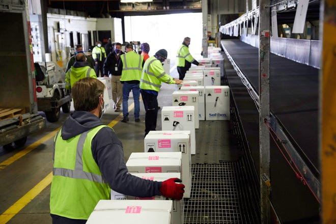 FedEx Express World Hub employees handle packages containing doses of the COVID-19 vaccine developed by Pfizer and BioNTech on Dec. 13, 2020, in Memphis.